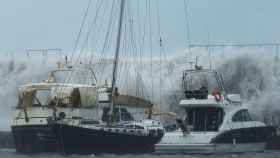 Espectaculares olas sobrepasan el espigón del Port Olímpic