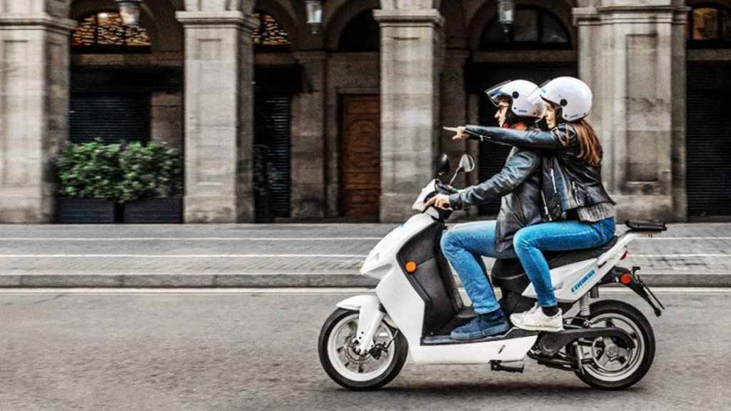 Una pareja circulando con una motocicleta del grupo Cooltra