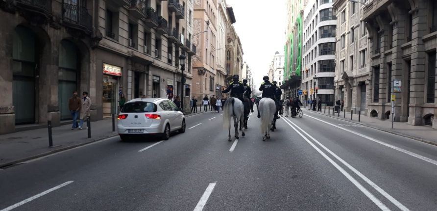 Agentes de la Guardia Urbana a caballo junto a un coche en Via Laietana / M A