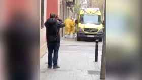 Persona haciendo fotos a los sanitarios que realizan una intervención por coronavirus en el barrio de Gràcia de Barcelona / CG