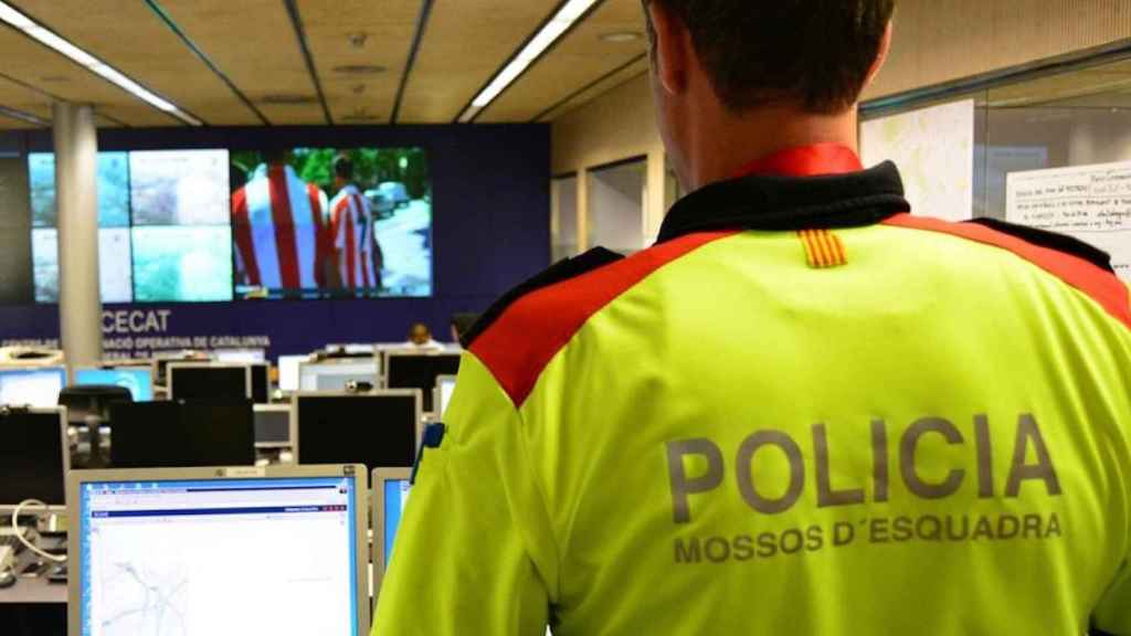 Un agente de los Mossos de espaldas en una sala de vigilancia informática