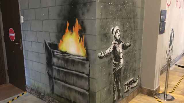 Obra de Banksy donde un niño juega con la nieve aunque en realidad son las cenizas del fuego