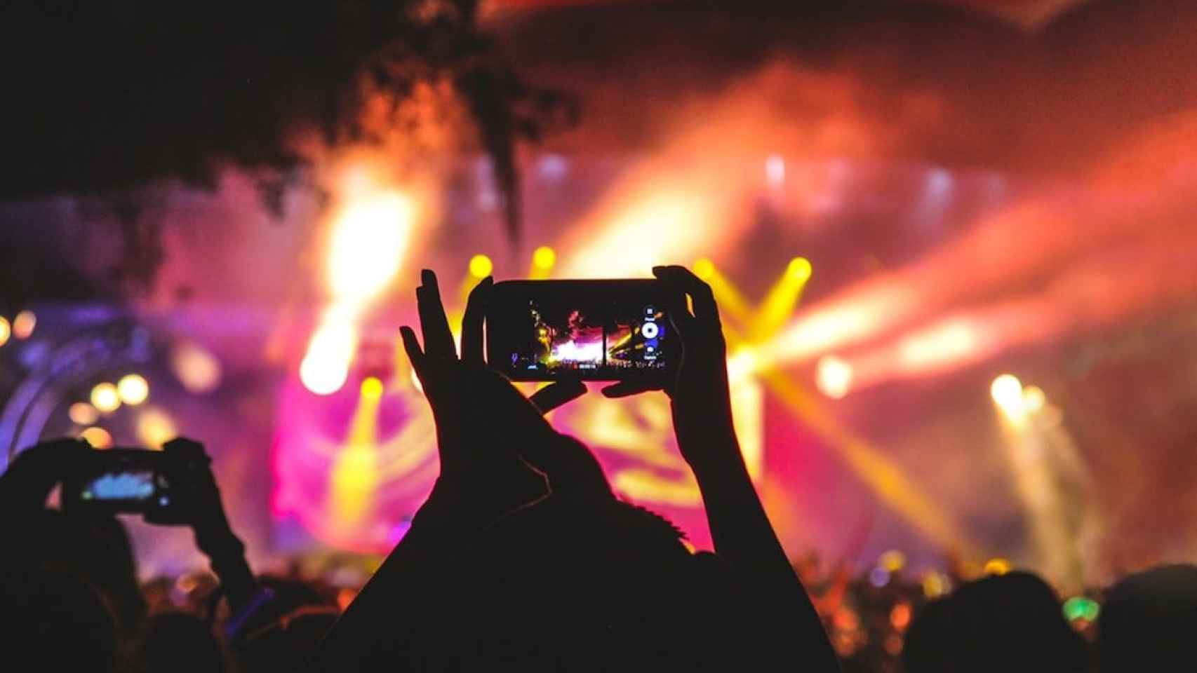 Persona sujetando un móvil en un concierto del Día de la Mujer en Barcelona / UNSPLASH