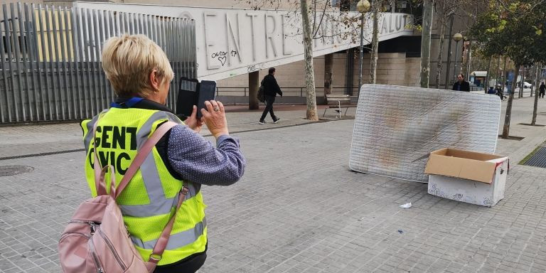 María Sola fotografía un viejo colchón y una caja abandonados en la calle frente al mercado de la Salud / G.A