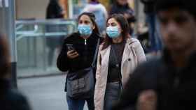 Dos personas con mascarillas por la calle / EP