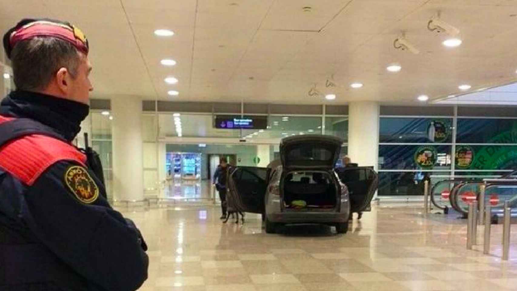 Coche de los arrestados en el Aeropuerto de Barcelona con un policía vigilando / EP