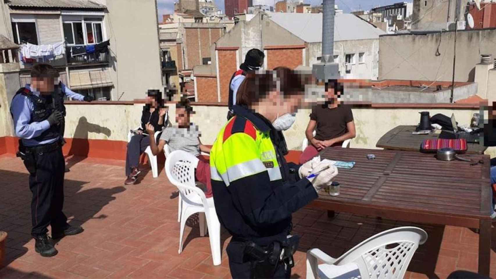 Agentes de los Mossos durante su actuación en la terraza de una casa particular en Sants / CG