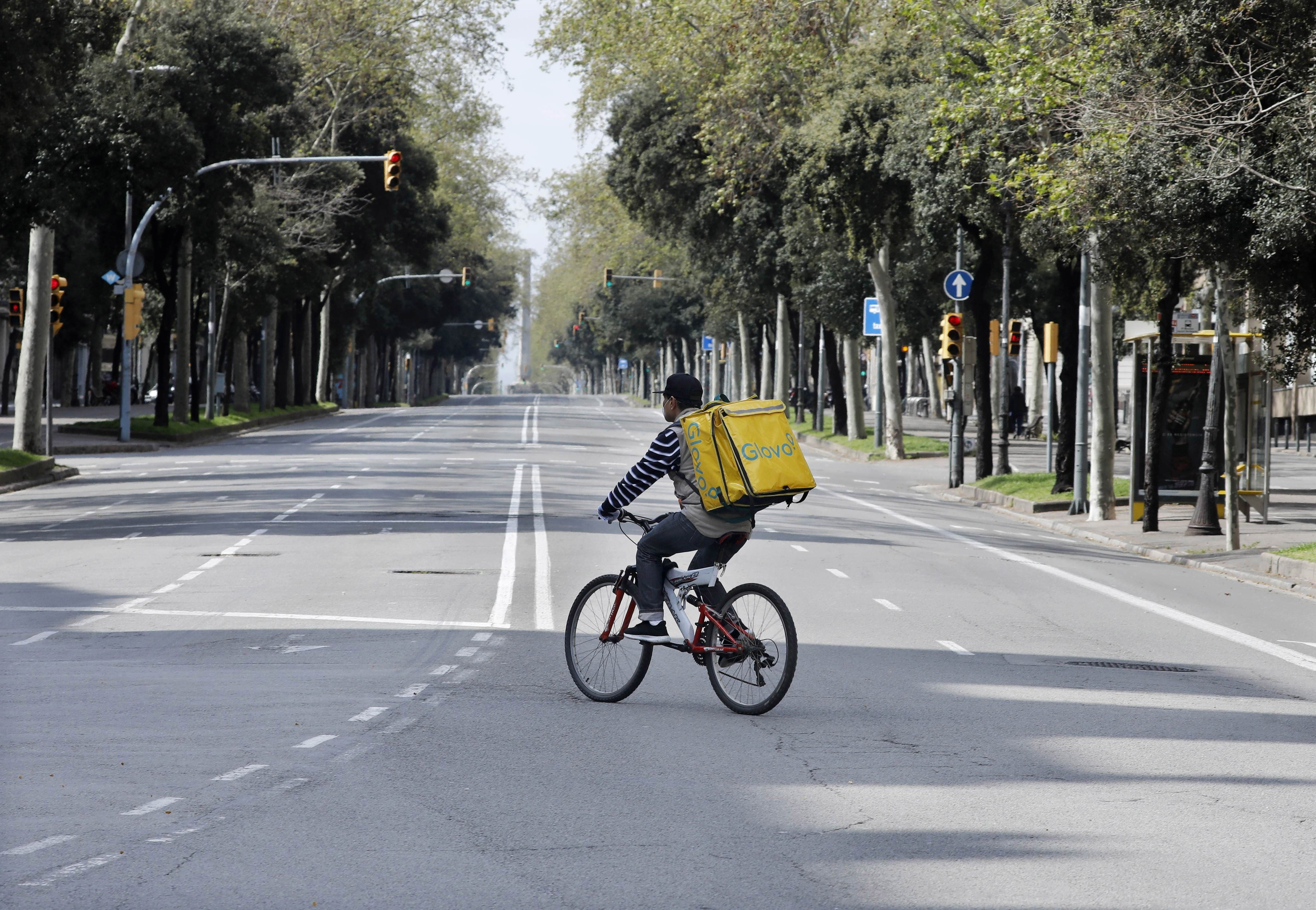 Un 'rider' de una empresa de mensajería circula solo por la Diagonal / EFE