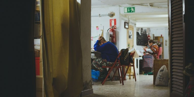 Al fondo, una mujer teje, mientras otra, se sujeta la cabeza con las manos / ANA AGRAZ