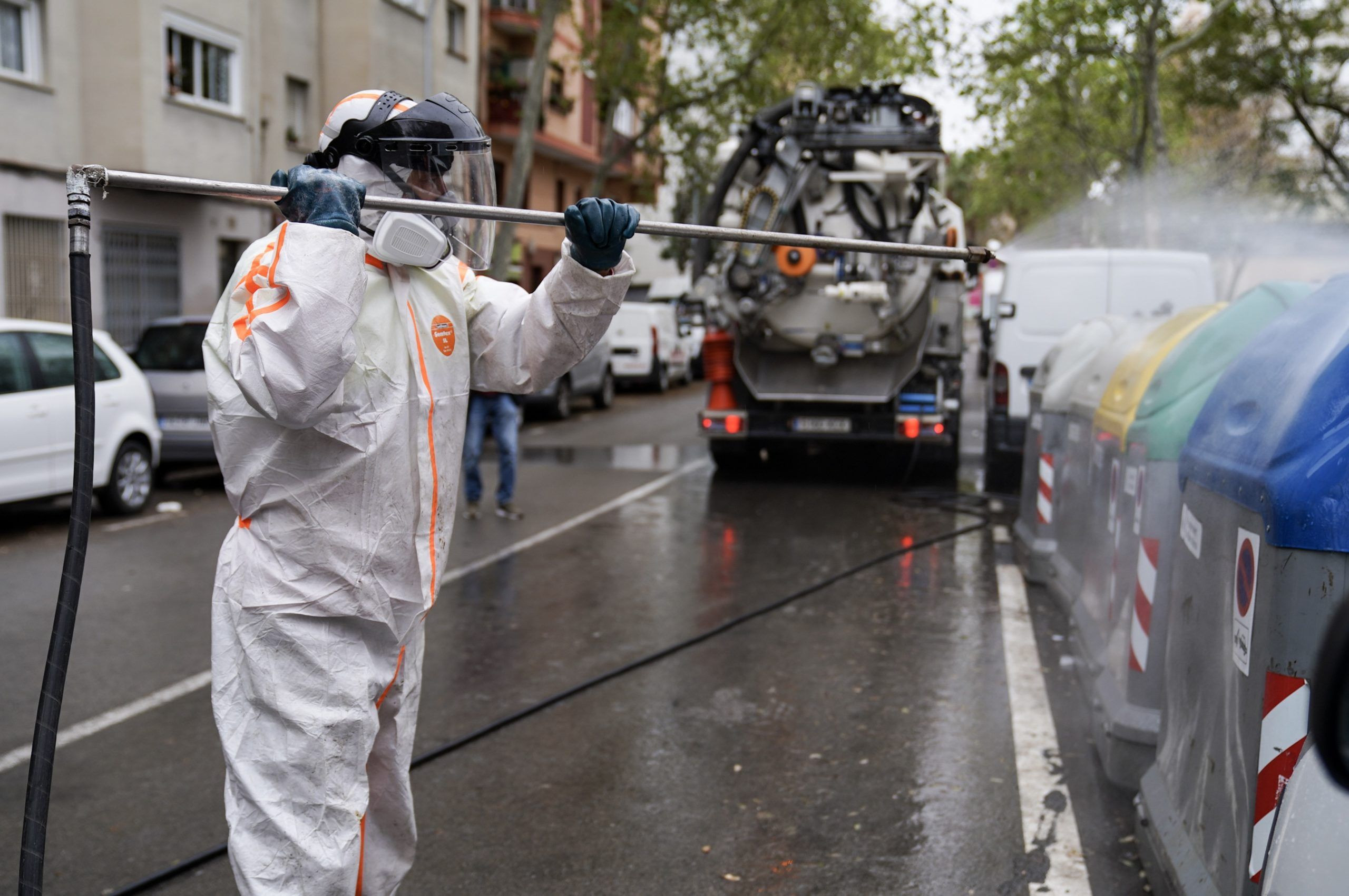 Un trabajador desinfecta un contenedor como medida de protección contra el coronavirus / AJ. DE BCN