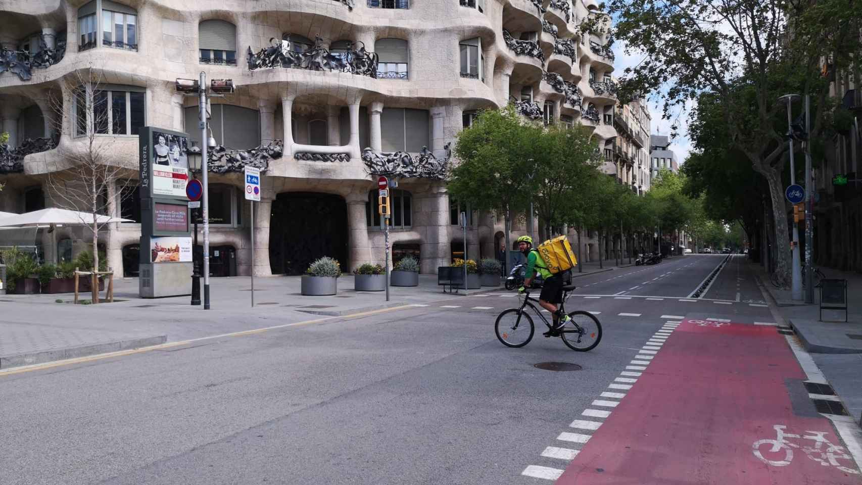 Un 'rider' de Glovo pasando por delante de La Pedrera / MA