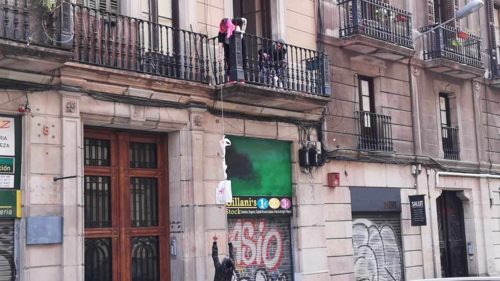 Una persona baja una bolsa a otra desde el balcón debido a la reclusión por coronavirus / G.A.