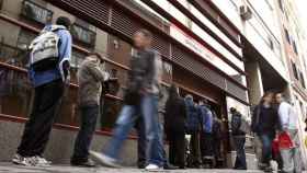 Personas entrando y saliendo de una oficina de empleo / EFE