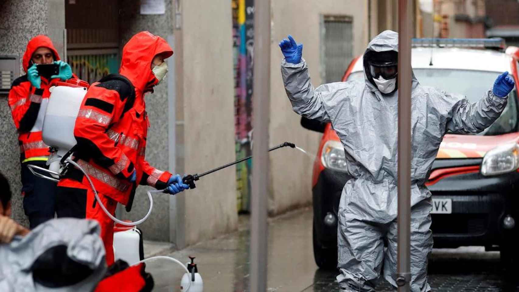 Un bombero desinfecta a otro tras salir de una residencia de ancianos con varios muertos / EFE ALBERTO ESTÉVEZ