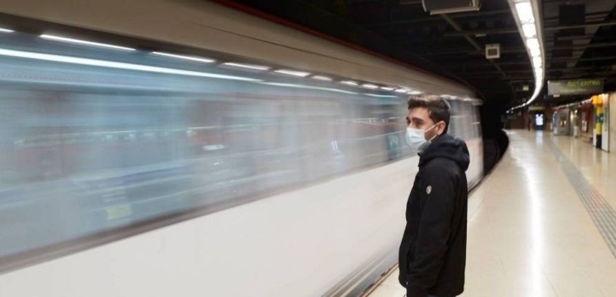 Un viajero con mascarilla espera el metro en Barcelona / EFE