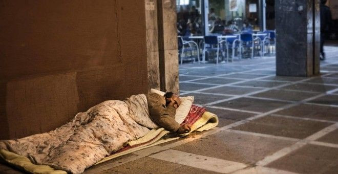 Un hombre sin techo duerme en la acera / EFE