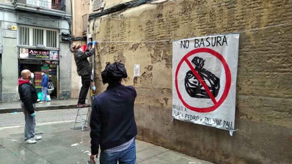 Cartel colgado por los vecinos de la calle dels Salvador para que se deje de lanzar basura en ese punto del Raval