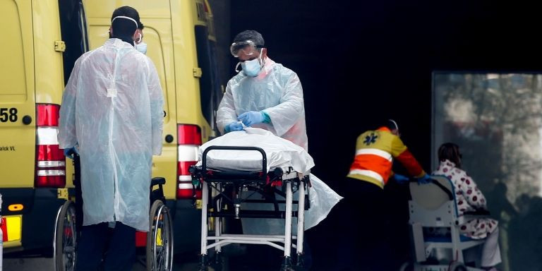 Sanitarios atienden a un paciente en la entrada del Hospital de Bellvitge / EFE