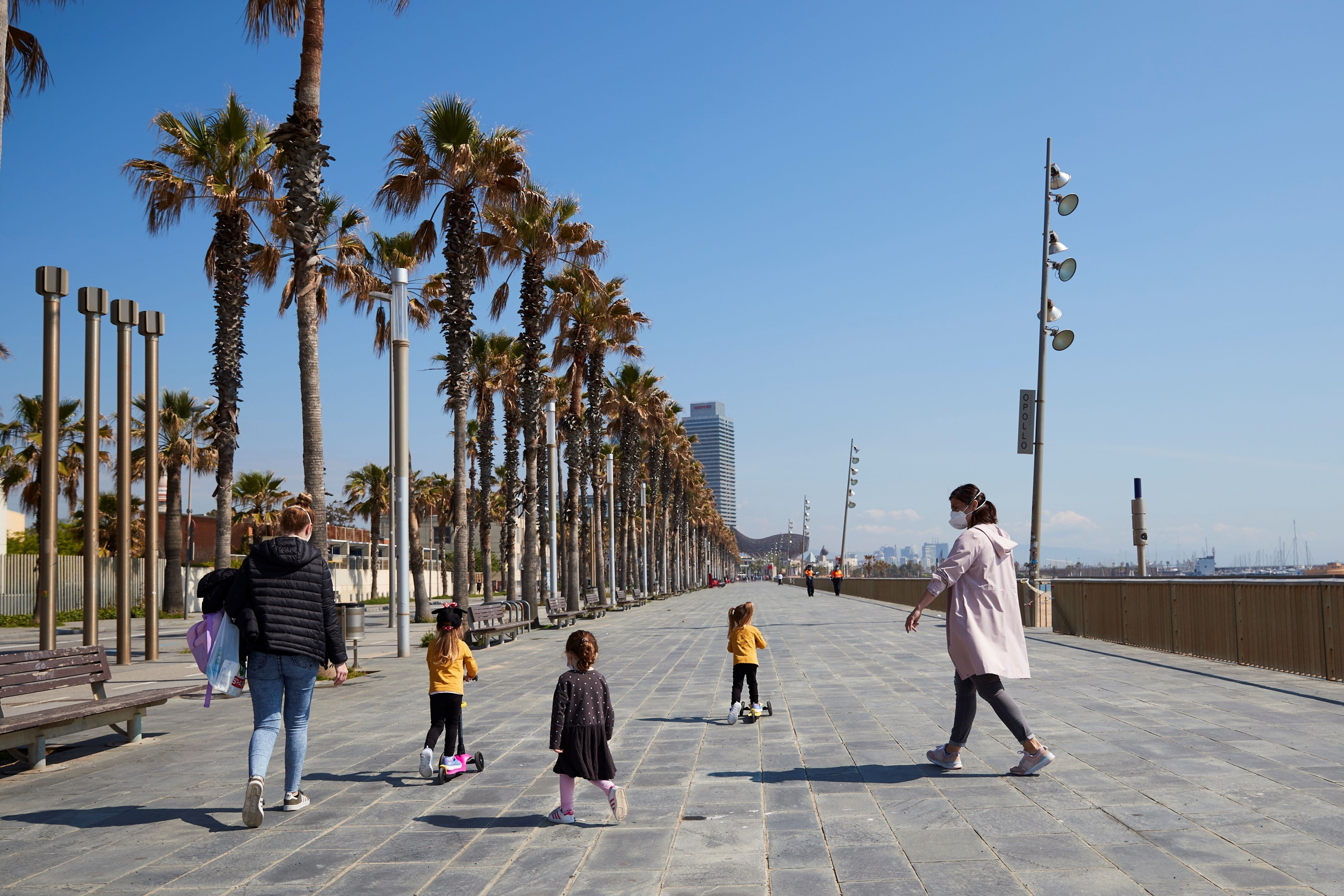 Dos mujeres con tres niños junto a las playas de Barcelona / EFE