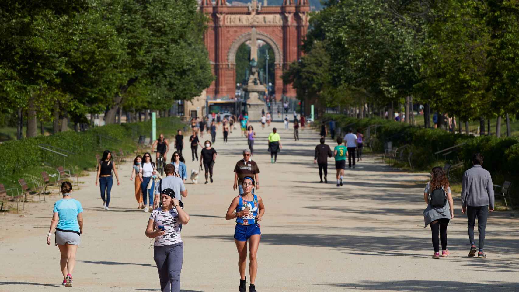 Decenas de personas pasean o corren por el parque de la Ciutadella bajo la atenta mirada de los voluntarios de Colau / EFE