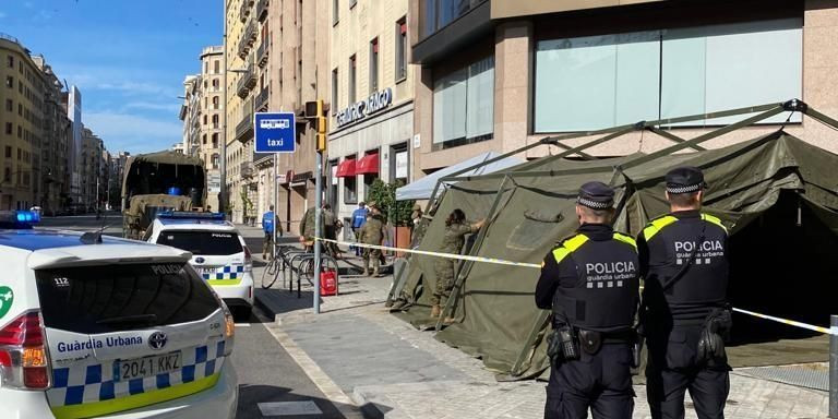 Agentes de la urbana observan a soldados del ejército durante el levantamiento de un pequeño campamento / GUARDIA URBANA