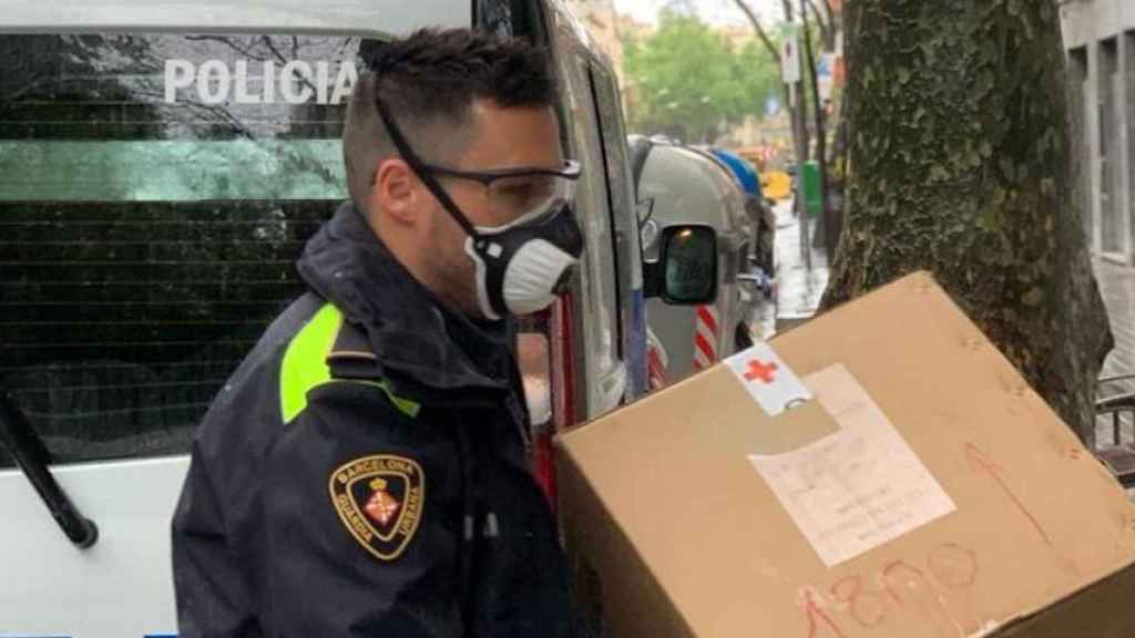 Un guardia urbano con mascarilla descarga un paquete / TWITTER GUARDIA URBANA