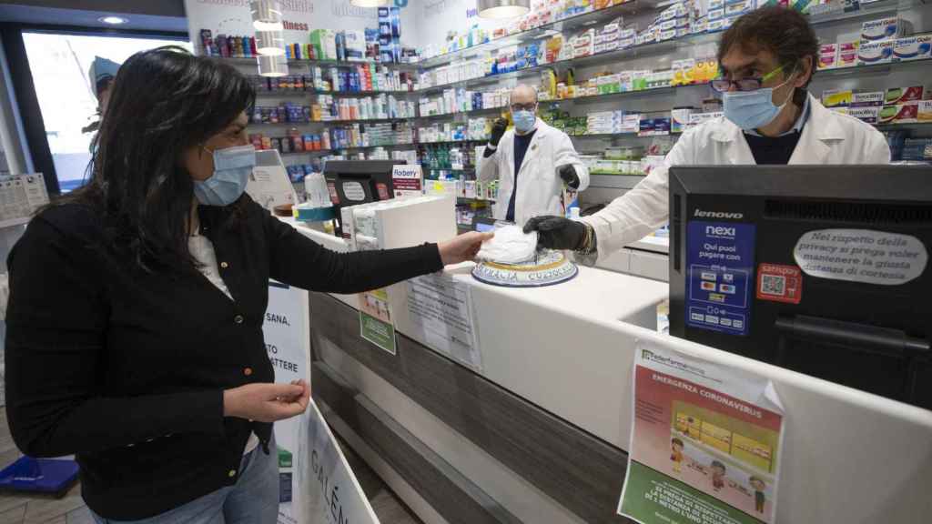 Un trabajador de una farmacia de Barcelona despachando a una cliente