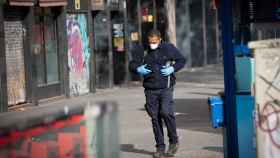 Un hombre camina por Barcelona protegido con mascarilla y guantes / EP