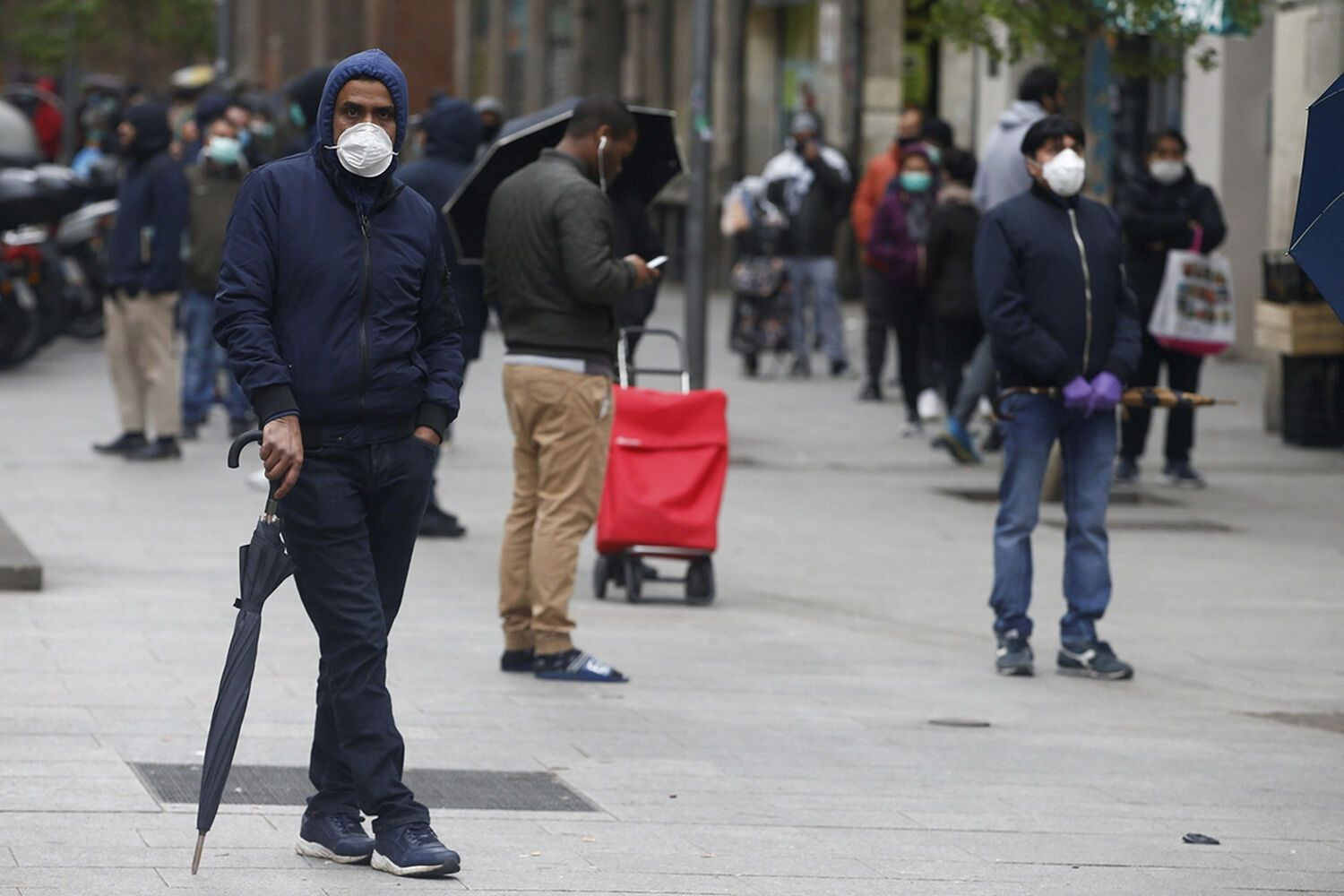 Decenas de personas hacen cola en el Centro de Servicios Sociales del barrio del Raval en una imagen de archivo / EFE