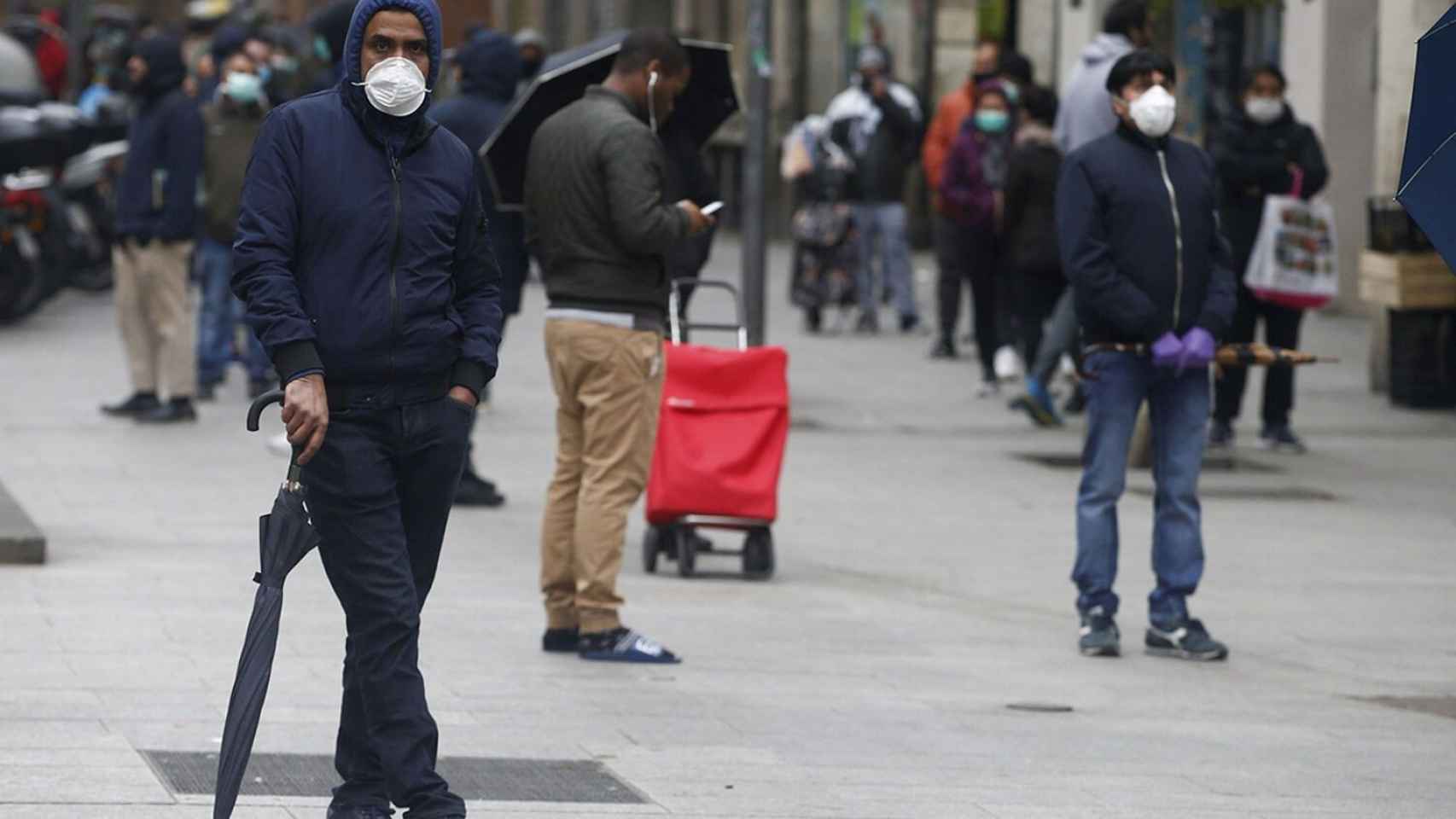 Decenas de personas hacen cola en el Centro de Servicios Sociales del barrio del Raval en una imagen de archivo / EFE