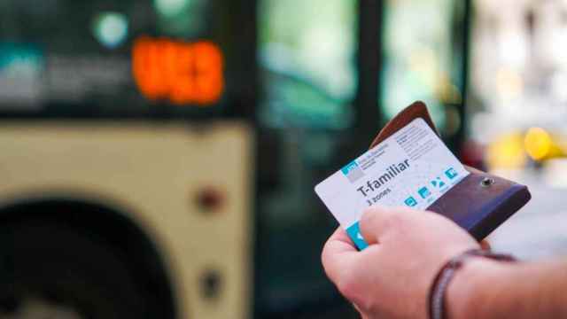 Un usuario del autobús sujetado un billete de TMB / EUROPA PRESS