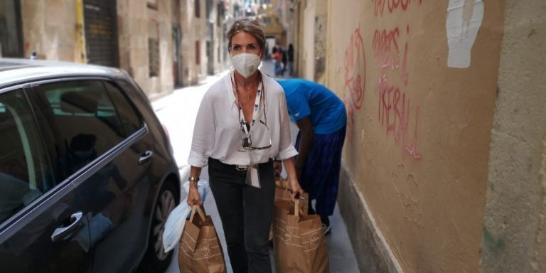 Loreto lleva bolsas de comida hasta la tienda Top Manta del Raval / G.A