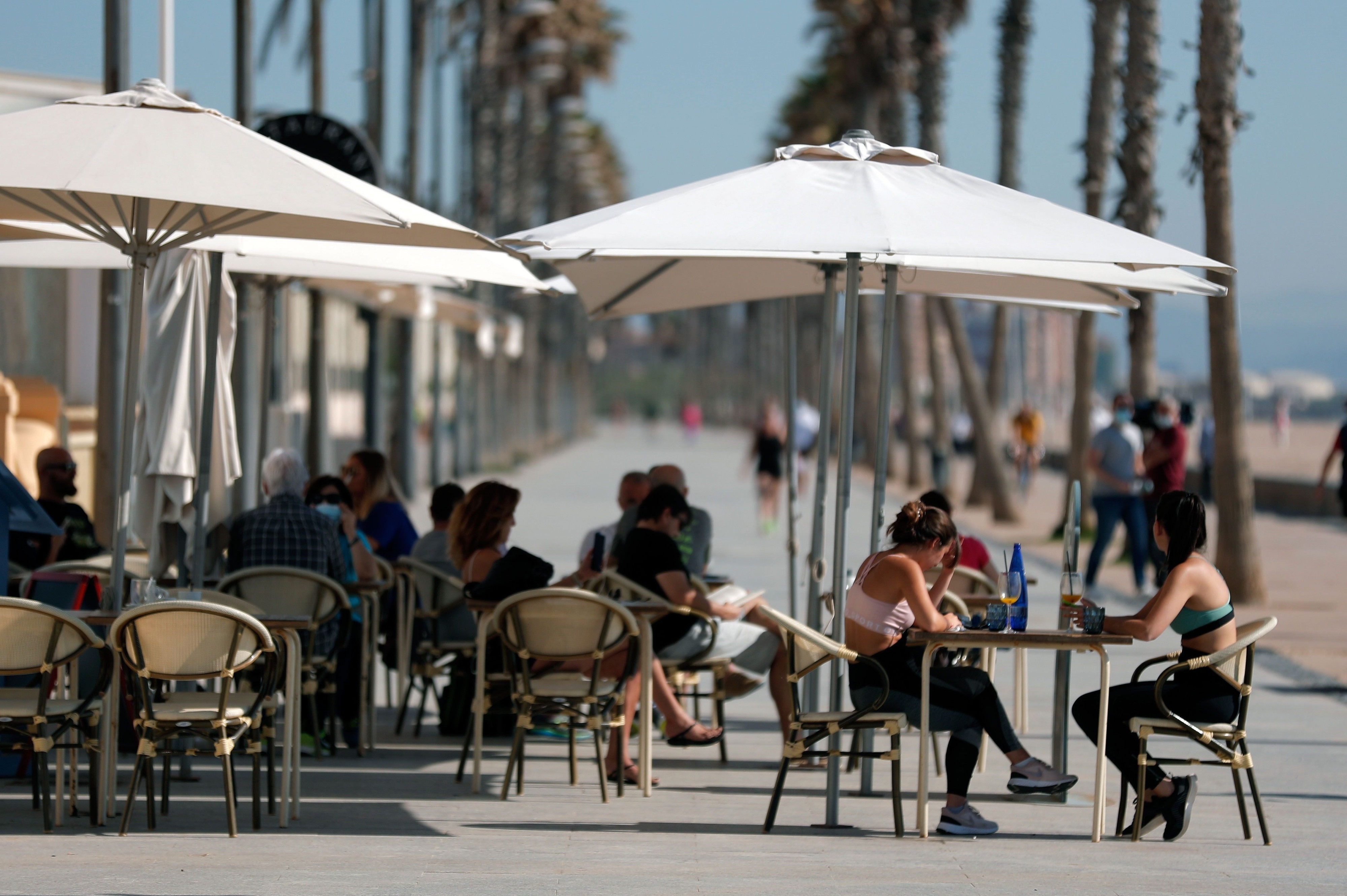 Una decena de personas en una terraza de la playa