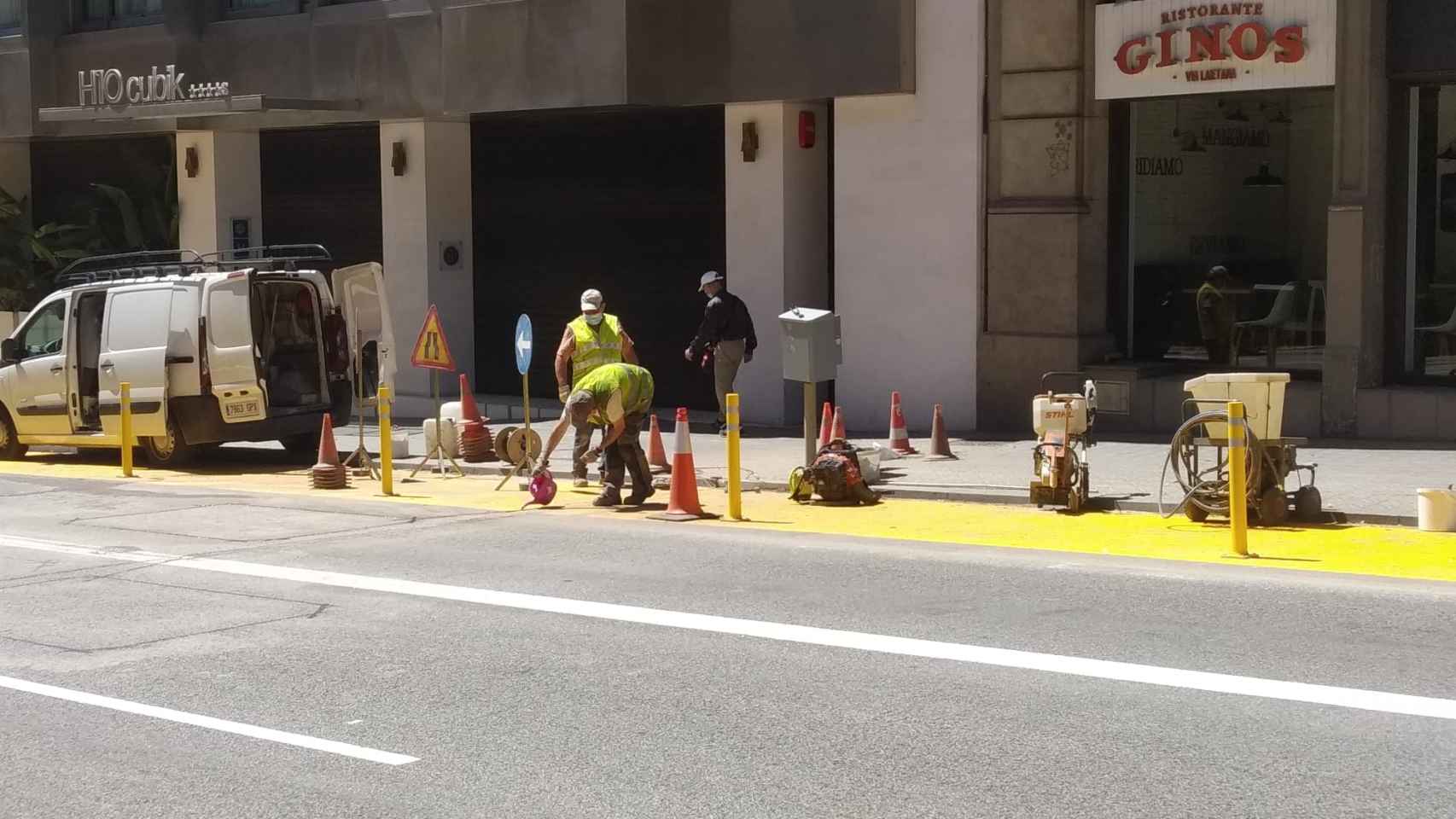 Operarios instalan pivotes entre la zona peatonal y el carril bus de Via Laietana / JORDI SUBIRANA