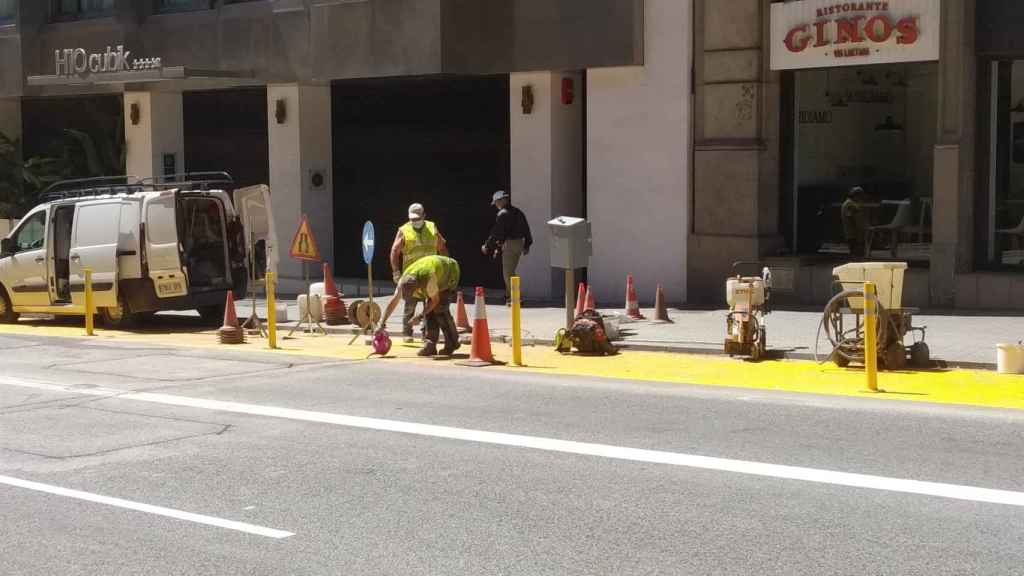 Operarios instalan pivotes entre la zona peatonal y el carril bus de Via Laietana / JORDI SUBIRANA