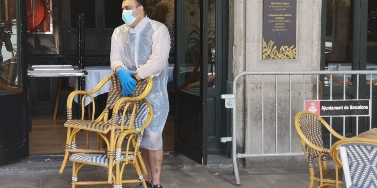 Un camarero prepara la terraza de un restaurante de la plaza Reial / G.A