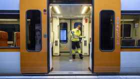 Interior de un tren con un operario desinfectando la zona