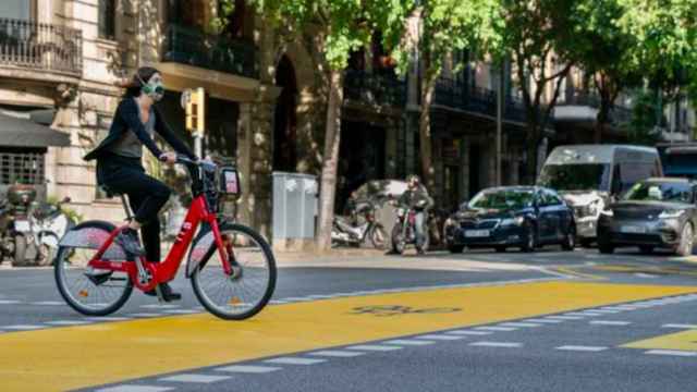 Una usuaria del Bicing con mascarilla en una calle de Barcelona