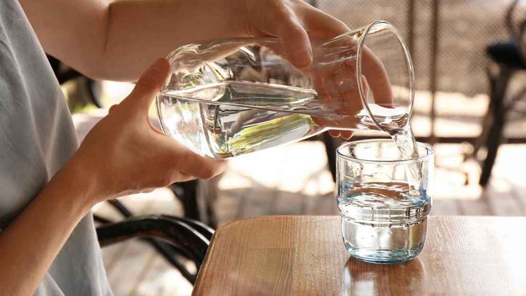 Un cliente de un bar con una jarra de agua en las manos