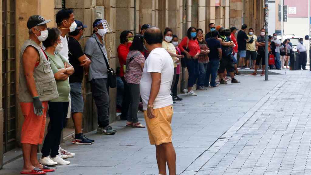 Una de las colas interminables para recoger comida en el barrio del Raval de Barcelona / EFE - Quique García