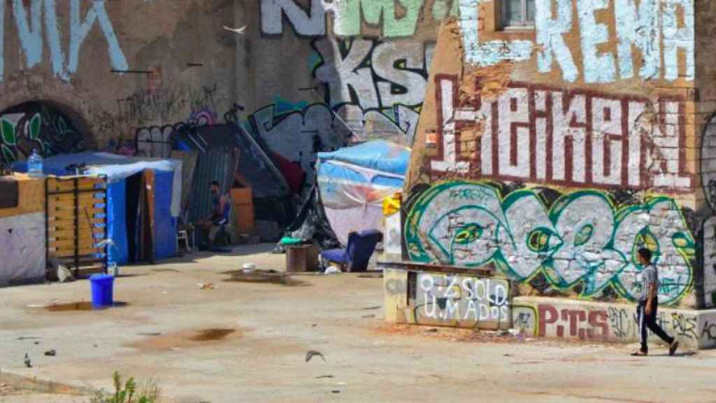 Tres jóvenes en el asentamiento de Bac de Roda / ELENA BURÉS