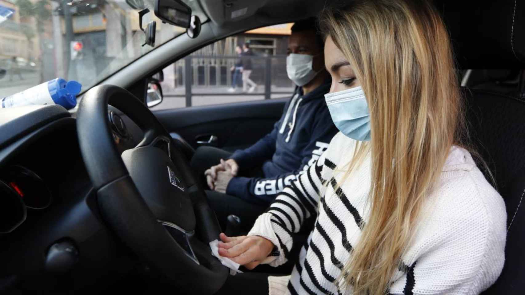 Dos pasajeros en un coche usando mascarillas / EFE