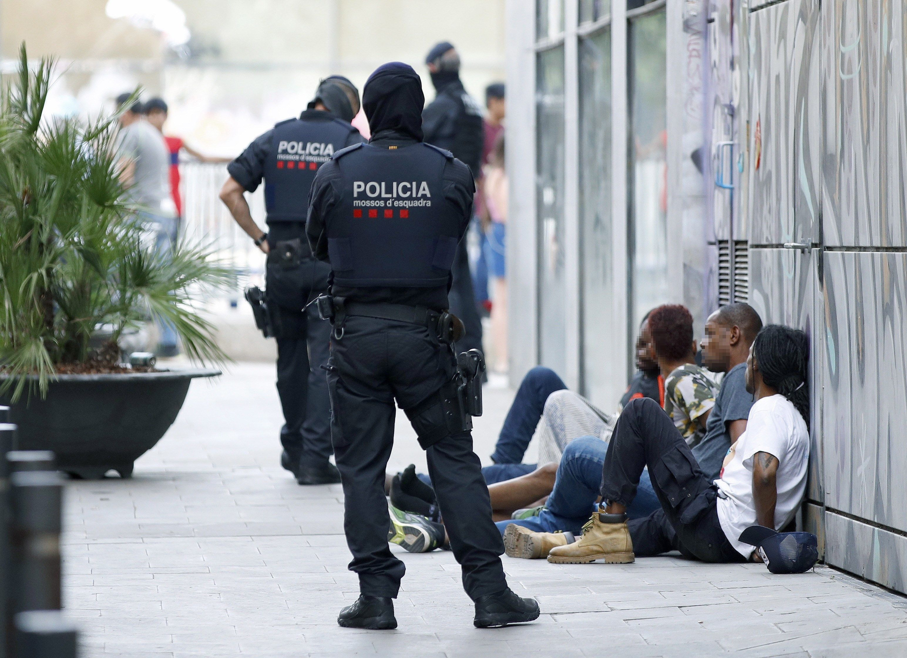 Mossos junto a un grupo de detenidos en el Raval / EFE