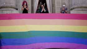 Ada Colau y representantes del colectivo LGTBI colgando la bandera en la fachada del Ayuntamiento de Barcelona / AYUNTAMIENTO DE BARCELONA