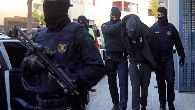 Agentes de los Mossos d'Esquadra con un detenido / EFE