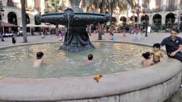 Varios niños se dan un chapuzón en la fuente de plaza Reial / MARTÍ CUSÓ - @marticuso