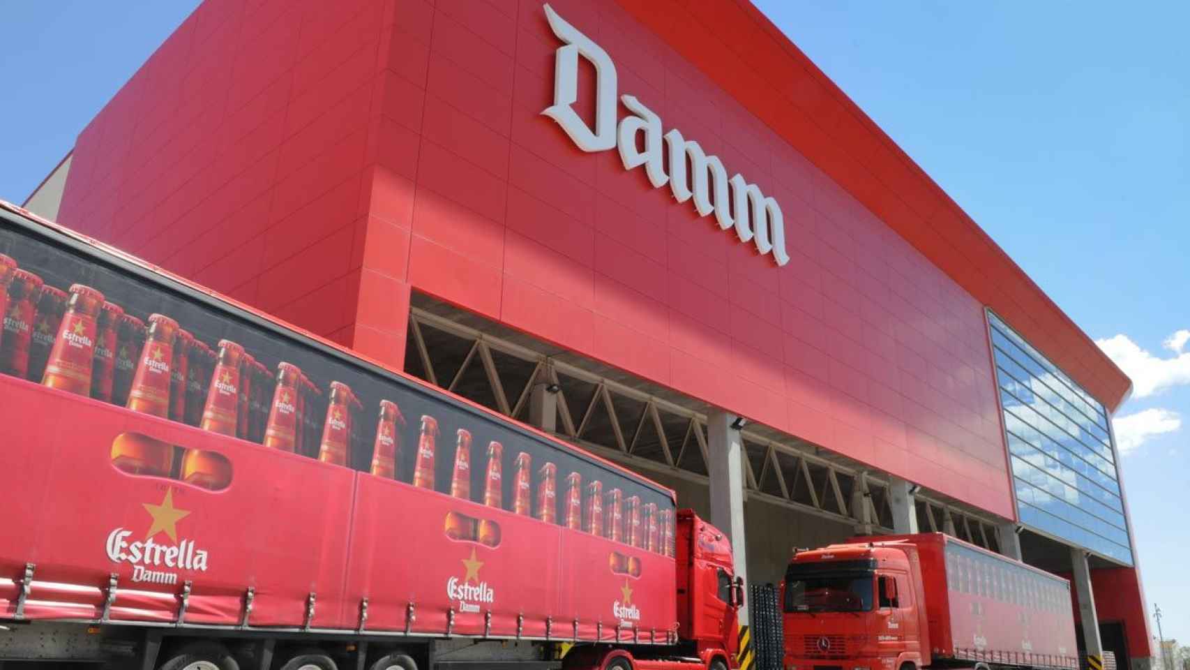 Exterior de la fábrica Damm con dos camiones estacionados