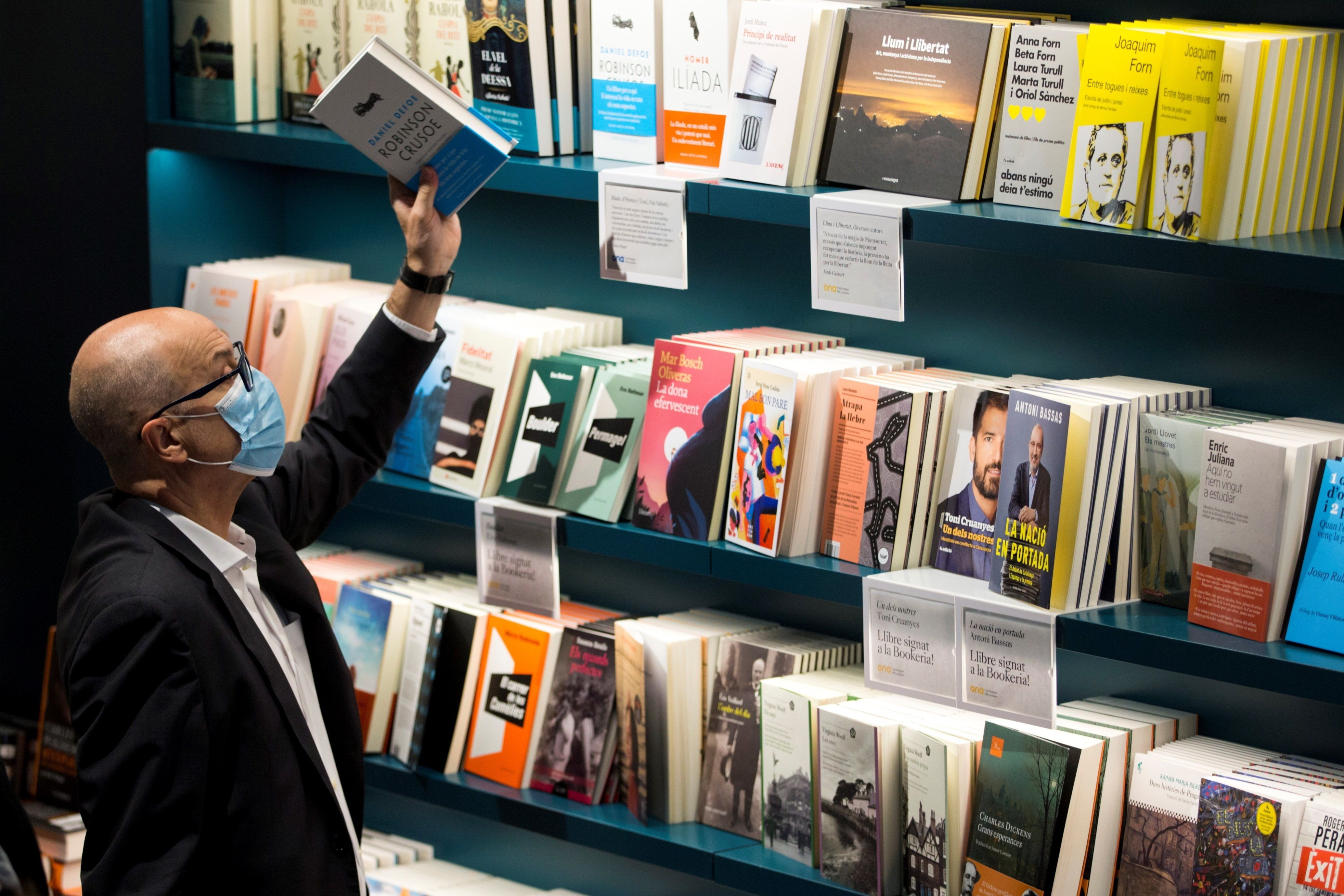 Un hombre sujeta un libro en una librería de Barcelona este jueves / EFE