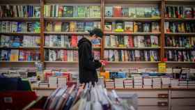 Un joven observa un libro de la papelería Demos, en Barcelona / EUROPA PRESS - David Zorrakino