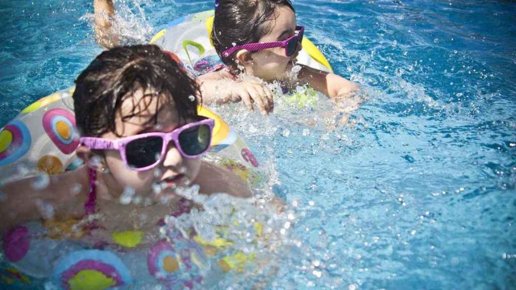 Niños en una piscina, lugar donde se puede contraer otitis en verano / PIXABAY